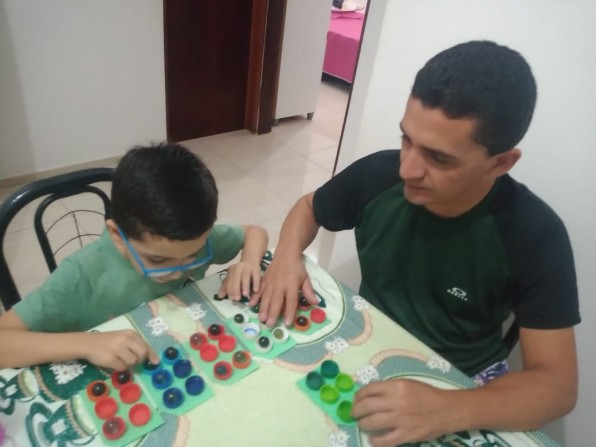 Pai aprende braile junto com o filho de baixa visão